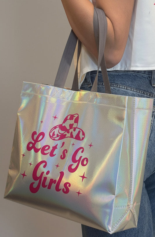 Person holding a holographic bag with 'Let's Go Girls' text.